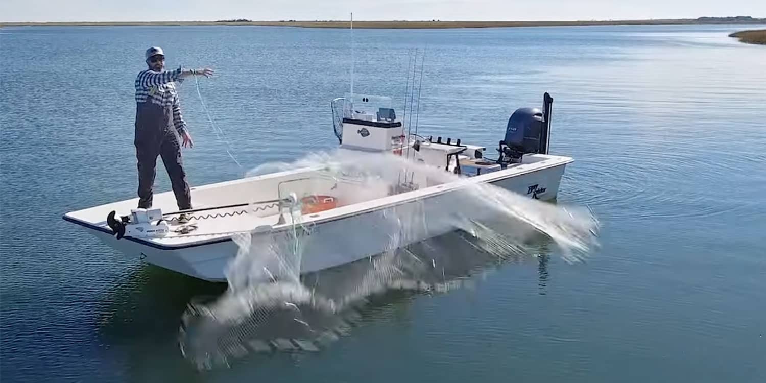Fisherman casting a net from a boat on open water, highlighting physical strain and back-intensive work on the water.